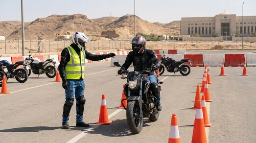 متدرب يتلقى تدريباً عملياً للحصول على رخصة قيادة الدراجة النارية